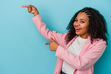 Young african american woman isolated on blue background excited pointing with forefingers away.