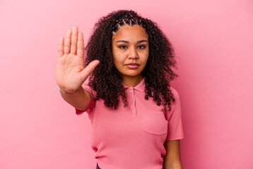 Young african american woman isolated on pink background standing with outstretched hand showing...