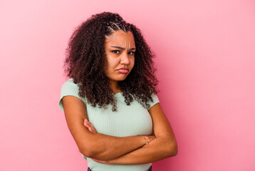 Young african american woman isolated on pink background blows cheeks, has tired expression. Facial...