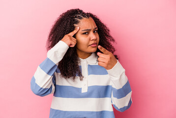 Young african american woman isolated on pink background pointing temple with finger, thinking, focused on a task.