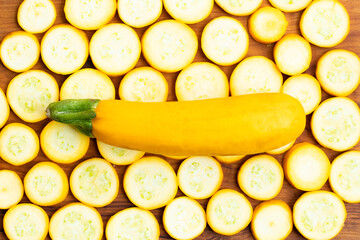 Whole Summer Squash Zucchini, Yellow Colored Gourd Also Known As Courgette, Baby Marrow, Indian Jugni Sabzi Or Jugnu Petha Sabji Placed On Round Shaped Sliced Pieces Decorated On Wooden Background