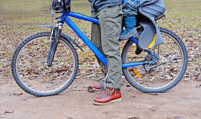 legs of parent and child with bicycle