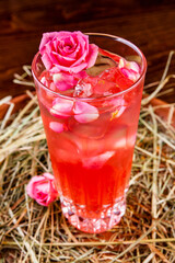 Summer cocktail decorated with pink rose. Close up
