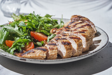 Fried chicken fillet and fresh vegetable salad with tomatoes.