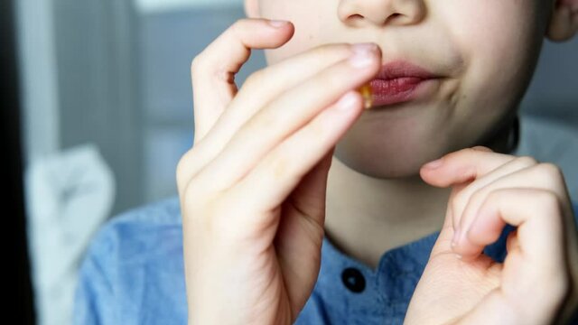 boy, kid holds in hand, wants to eat gelatinous sweets, gummy bear, concept of children's delicacy, healthy and unhealthy food, halal food