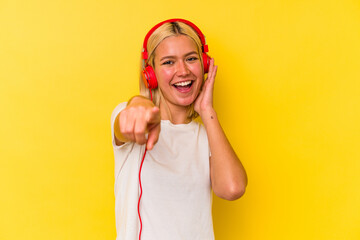 Young venezuelan woman listening music isolated on yellow background