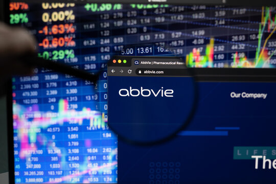 AbbVie Inc. company logo on a website with blurry stock market developments in the background, seen on a computer screen through a magnifying glass