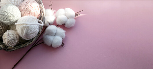 Basket with balls of thread. Gift boxes. Decorations for the holiday. Delicate colors, pink background.