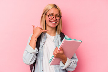 Young venezuelan student woman isolated on pink background showing a mobile phone call gesture with fingers.