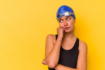 Young swimmer venezuelan woman isolated on yellow background who feels sad and pensive, looking at copy space.