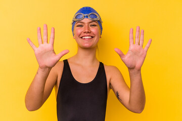 Young swimmer venezuelan woman isolated on yellow background showing number ten with hands.