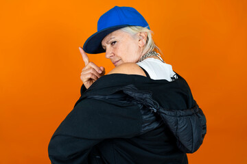 Funny portrait of mature woman. Lady having fun dressed as an angry rapper