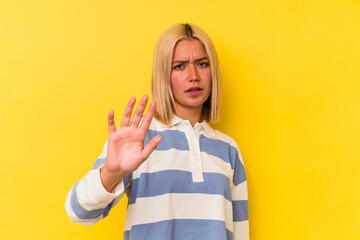 Young venezuelan woman isolated on yellow background being shocked due to an imminent danger
