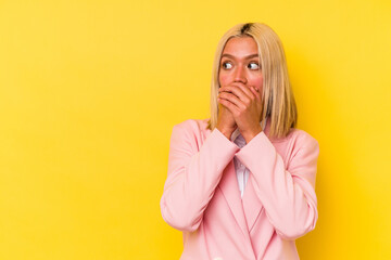 Young venezuelan woman isolated on yellow background thoughtful looking to a copy space covering mouth with hand.