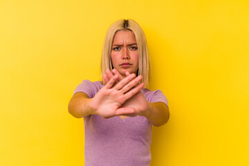 Young venezuelan woman isolated on yellow background doing a denial gesture