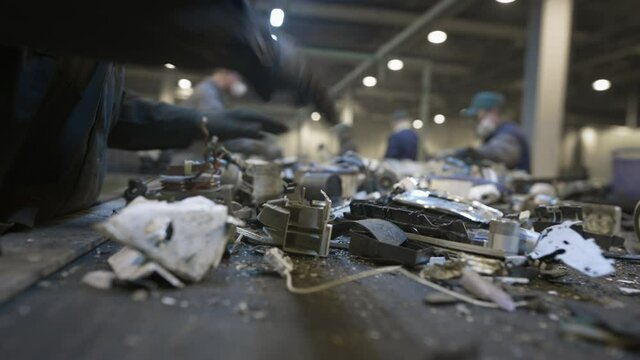 A male worker sorts and recycles electronic waste and scrap metal