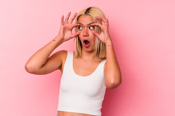 Young venezuelan woman isolated on pink background keeping eyes opened to find a success opportunity.