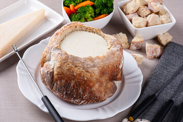 .Creamy cheese fondue inside Italian bread