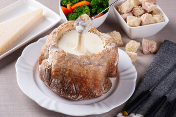 .Creamy cheese fondue inside Italian bread