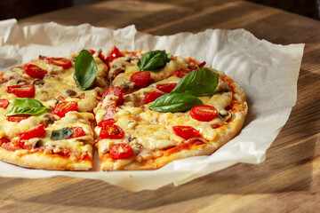 Homemade pizza on a wooden table, side view, selective focus.