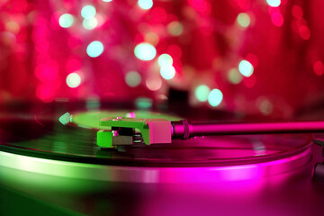 close-up of a pickup head on a vinyl record, color illumination, analogue retro music concept, audio experience, relaxation, musical enjoyment, vintage technology © kittyfly