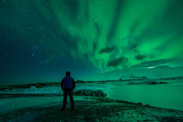 a man from the back watching the northern lights. Aurora borealis. 