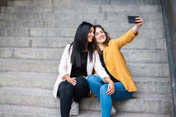 girls sitting on a ladder taking a picture