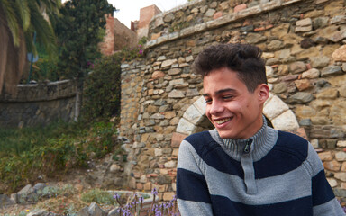 A handsome young cheerful Hispanic guy wearing a sweater