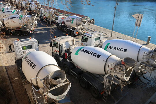 Trois camions malaxeurs de ciment / béton en stationnement sur le parking de l'entreprise de cimenterie Lafarge, au bord de la Seine à Paris – mars 2021 (France)