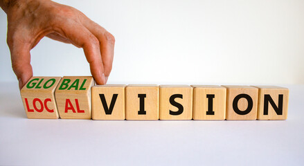 From local to global vision. Businessman turns cubes and changes words 'local vision' to 'global vision'. Beautiful white background, copy space. Business, local or global vision concept.