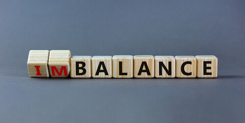 Balance or imbalance symbol. Turned cubes and changed the word imbalance to balance. Beautiful grey background, copy space. Business, balance or imbalance concept.
