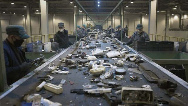 Male workers sort and recycle electronic waste and scrap metal