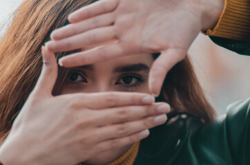 Close up de chica enmarcando sus ojos con sus manos