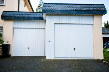 Obraz na płótnie Canvas wide garage door and concrete driveway in front