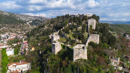 Fototapeta na wymiar Aerial drone view of historic fortress on the hill. Old castle on a rock. Old town Vidoski on the hill above city of Stolac, Bosnia and Herzegovina. 