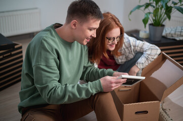 During the move to the new house, the husband and wife unpack the boxes with their things, they saw a frame with a photo and remember the past