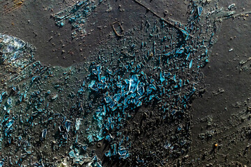 Shattered blue glass on pavement