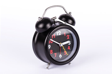 Black vintage retro alarm clock on the white background.
