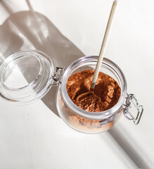 cinnamon powder in glass jar with a golden spoon