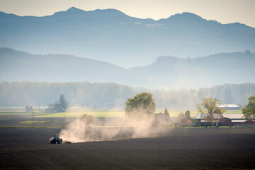 Farm Tractor Plowing a Field to Prepare for Planting. Springtime means a new season for planting crops and tilling the soil.