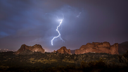 Lighting from a thunderstorm strikes inside Garden of the Gods State park at night in Colorado...