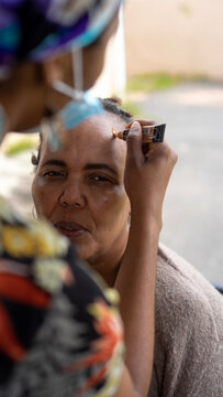 Elderly black woman getting makeup done