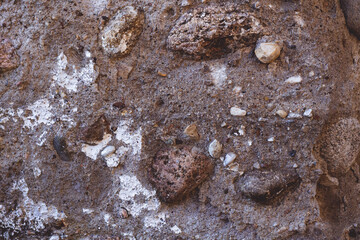 Background texture. Aged concrete surface with stones and white paint residues. Top view. Copy space