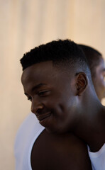 close-up profile of smiling beautiful young black man embracing friend