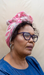 close-up portrait of elderly black woman in head wrap and reading glasses