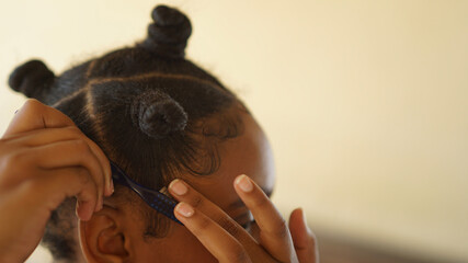 close up of a young woman laying her hair edges down © Cole Ndelu