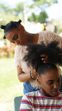 Sister combs through younger sister's hair