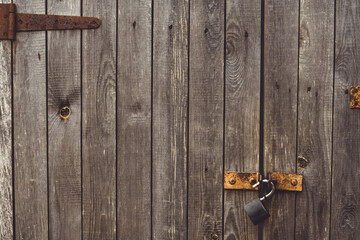 Background texture. Aged wood doors with rusty metal rivets and barn lock. Copy space