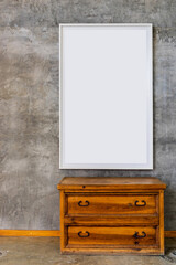 White vertical poster mock up on the concrete grey wall with wooden chest of drawers