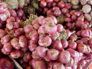 pile of red onions for sale on market.